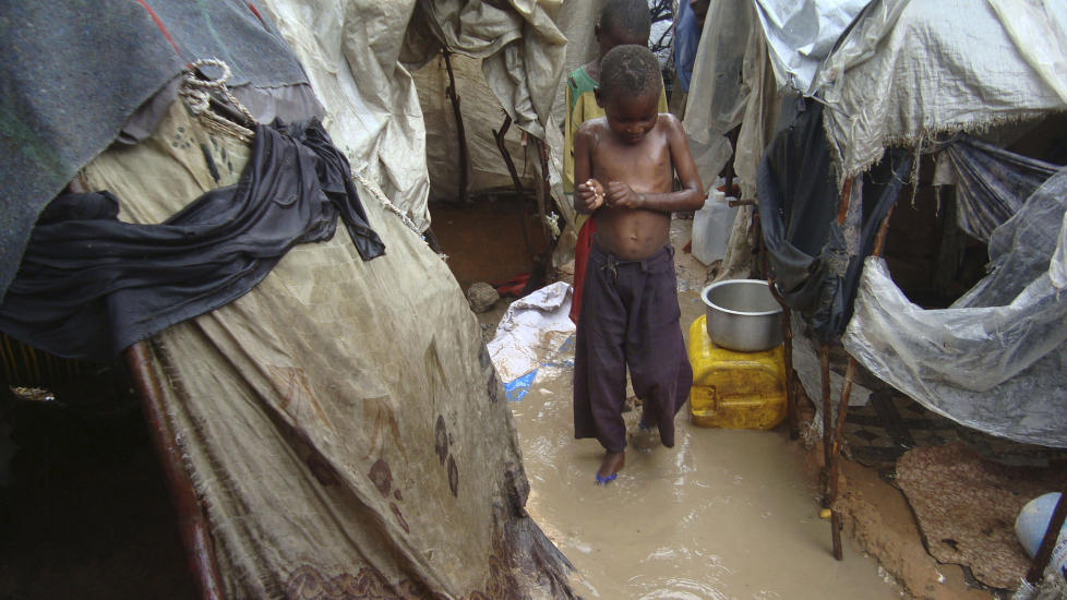 GJ�RMETE: En somalisk gutt st�r i regnvannet i en flykntingsleir i Mogadishu. Mange barn har nedsatt immunforsvar etter � ha sultet lenge og f�r fortere sykdommer som sprer seg med regnet. Foto: AP Photo/Farah Abdi Warsameh