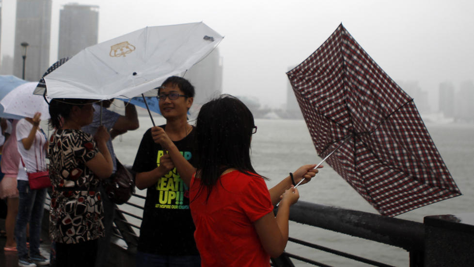  DE VRENGTE PARAPLYERS HELG:  Shanghai slapp unna tyfonen Muifa, men turister p� det kjente utkikkepunktet The Bund har likevel mer enn nok med � holde p� paraplyene i dag. FOTO: EUGENE HOSHIKO, AP/SCANPIX.