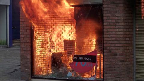 I BRANN: En butikk i Manchester er satt fyr p� av p�bler. Foto: EPA/Dave Thompson/Scanpix