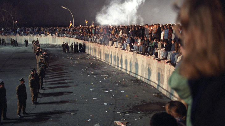 BERLINMURENS FALL:
Tusenvis av mennesker krabbet opp p� muren ved Brandenburger Tor i Vest-Berlin. P� �stsiden sto store politistyrker og passet p� at ingen kom over. Bildet er tatt 10 november 1989,
Foto: J�rn H. Moen/SCANPIX