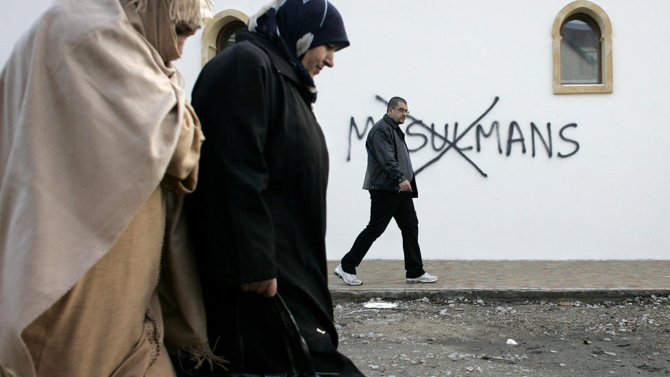 ISLAMOFOBI: Muslimske innbyggere i Saint-Etienne i Frankrike g�r forbi anti-muslimsk grafitti sprayet p� den lokale moskeen. Foto: Scanpix.