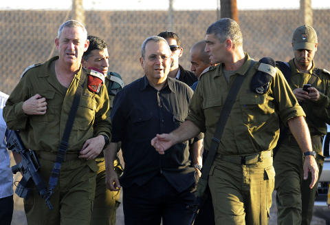 IKKE I TVIL: Israels forsvarsminiester Ehud Barak (i midten) og forsvarssjef Benny Gantz (t.v.) ankommer �stedet for dagens angrep. Barak er ikke i tvil om at palestinere fra Gaza st�r bak aksjonen. Foto: DAVID BUIMOVITCH / AFP / SCANPIX