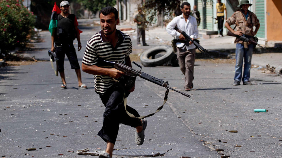  En oppr�rer l�per for � unng� snikskytterild i byen Zawiya, rundt 40 km vest for Tripoli hvor det avgj�rende slaget om Libya muligens er i gang. Foto: AFP PHOTO/MARC HOFER/SCANPIX