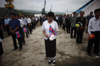 H�YTIDELIG FEIRING: Med nordkoreanske flagg og kunstige blomster, �nsket de vel 500 framm�tte fra lokalbefolkningen cruiset en god reise. Foto: CARLOS BARRIA/REUTERS/SCANPIX