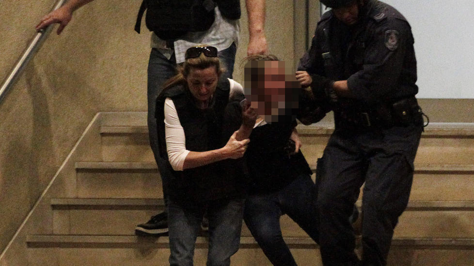 LIVREDD: Her reddes jenta ut av tungt bev�pnet politi. Foto: Reuters/Daniel Munoz/Scanpix