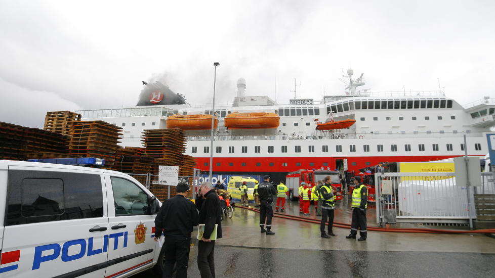 EVAKUERES: Hurtigruta brenner ved kai i �lesund. Tolv personer er brakt til sykehus etter brannen.  Det brenner fortsatt i hurtigruteskipet, og fire personer er savnet. Foto: Svein Ove Ekornesv�g / Scanpix