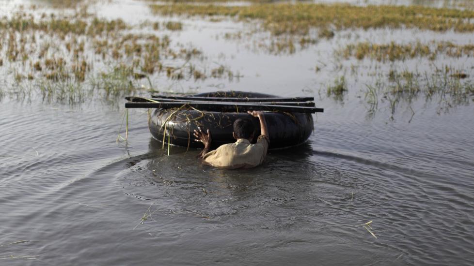 REDDER STUMPENE: En mann pr�ver � redde eiendeler gjennom voldsomme vannmasser i Hyderabad-omr�det i Pakistan. Hundretusener er drevet p� flukt av flommen. Foto: AP/Muhammed Muheisen/Scanpix