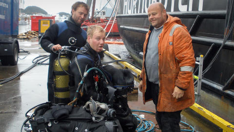 ARBEID UTF�RT: Dykkerne fra Dykkerkompaniet er ferdig med jobben og er rimelig slitne. Bak er det dykker H�vard S�vik som assisterer kollega Joakim Gamlem. Daglig leder Knut Ness til h�yre. Foto: Dykkerkompaniet