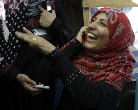 GLAD: Tawakkul Karman ler mens hun snakker p� telefon etter � ha mottatt Nobelsfredspris. Til Al-Jazeera sier hun at hun er veldig glad for prisen. Foto: AP Photo/Hani Mohammed