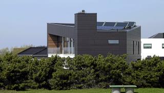 MILJ�RIKTIG: Villa Alstrup tegnet av arkitektfirmaet C.F. M�ller er oppf�rt med b�redyktige materialer. Blant annet er det isolert med papirganulat som er et gjenbruksprodukt. Huset er kledd med fiberbetong, noe som gj�r bygningen n�rmest vedlikeholdsfri. Legg merke til solcellepanelene p� taket.  Foto: Helene Mikkelsen