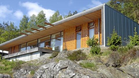 BESKYTTENDE FRONT: Her ser du hvordan takutstikket fungerer som en beskyttende skjerm foran selve bygningskroppen. Taket er tekket med gr�patinert titansink.  Foto: Haga Grov