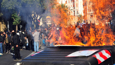 FORBANNET: Biler sto i brann og maskerte demonstranter angrep politiet i Roma i dag. Foto: AFP/Scanpix
