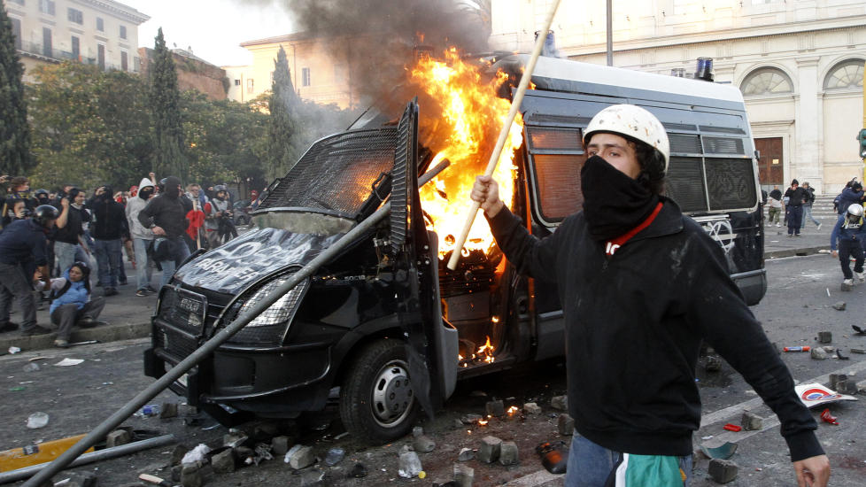 Italiensk oppr�rspoliti brukte t�regass og vannkanoner for � spre demonstranter i Roma etter at en stor gruppe aktivister hadde satt fyr p� en bygning og flere biler l�rdag. Foto :REUTERS/Alessandro Bianchi/SCANPIX