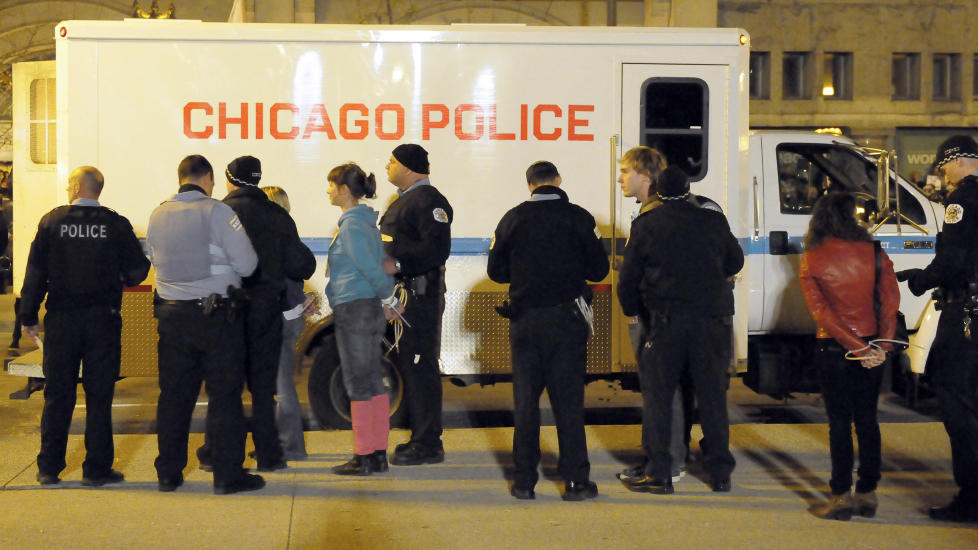 ST�R SKOLERETT: Bev�pnet politi tok h�nd om de 175 demonstrantene i Chicago i kveld norsk tid. Foto: AP/Chicago Sun-Times/Scott Stewart/Scanpix