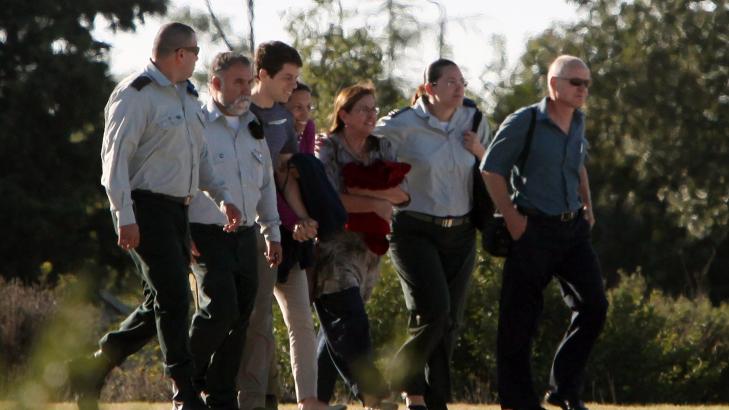 FORVENTNINGSFULLE:  Foreldrene til den frigitte israelske soldaten Gilad Shalit, Noam (t.h) og Aviva (3 t.h) har med seg sin andre s�nn, Yoel og hans kj�reste Ya'ara Winkle (midten). Familien blir fulgt av offiserer i det israelske luftforsvaret, utenfor huset deres i Nord-Israel. M�let er en milit�rbase like utenfor Tel Aviv, hvor de i l�pet av dagen skal gjenforenes med Gilad Shalit.Foto: Dror Artzi/Scanpix