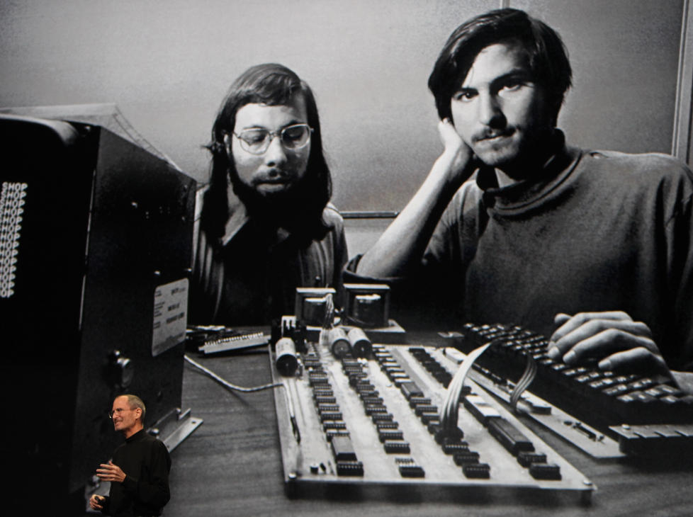HISTORISK: Apple-sjef Steve Jobs under lanseringen av nettbrettet iPad i 2010, foran et gammelt bilde av ham selv og co-grunnlegger Steve Wozniak. Den offisielle biografien om Jobs holder seg mest p� �rb�dig avstand, skriver Dagbladets anmelder. Foto: Reuters / Scanpix