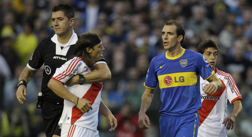 BOK OM BYDERBY: Linjemannen med et fast tak om River Plate-trener og tidligere Lyn-spiller Matias Almeyda etter at han ble utvist under byderbyet mellom River Plate og Boca Juniors i Buenos Aires i v�r. River tapte kampen og endte med � rykke ned for f�rste gang i klubbens historie. Foto: AP