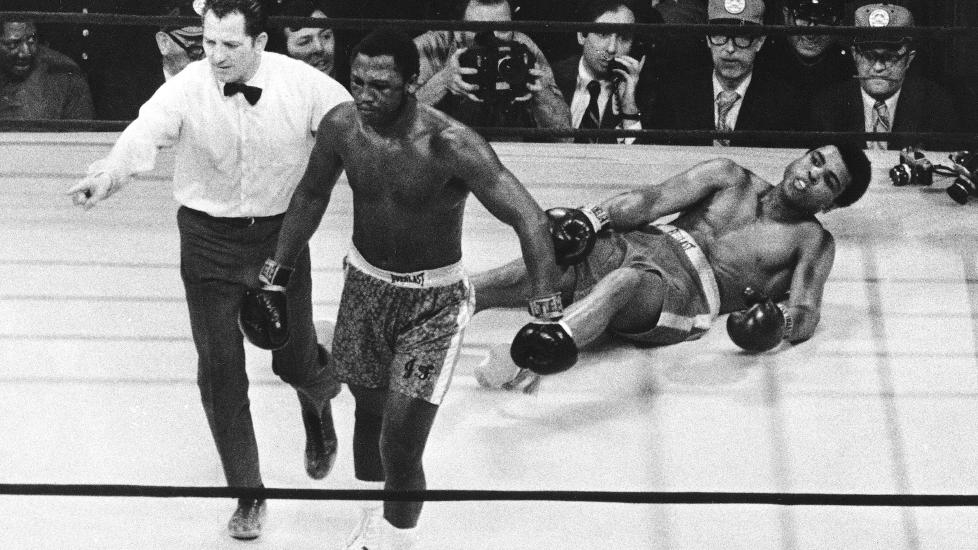 SLO ALI: Joe Frazier vises tilbake til hj�rnet sitt etter � ha sendt Muhammad Ali i bakken i tittelkampen i Madison Square Garden i New York 8. mars 1971. Frazier vant kampen, og ble den f�rste som beseiret Ali. De to m�ttes i flere legendariske kamper. Foto: AP/Scanpix