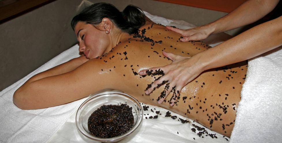 DRUESPA: Det ser ut som Leslie Avan f�r innsmurt kroppen med svarte maur, men det er heldigvis bare druesteiner i blandingen som Elodie Gonzalez sm�rer p�. Pluss honning, sukker og druekjerneolje. Foto: EIVIND PEDERSEN