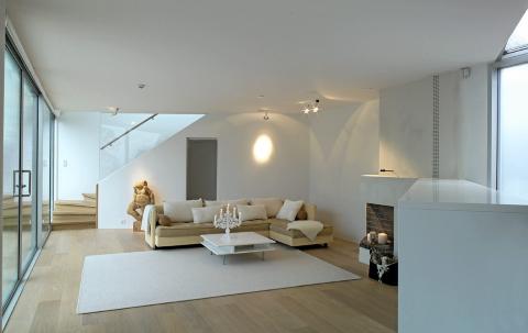 DAGSLYSET RULER: Med glass fra gulv til tak i hele fasaden flommer dagslyset inn i stuen.  FOTO: Emile Ashley