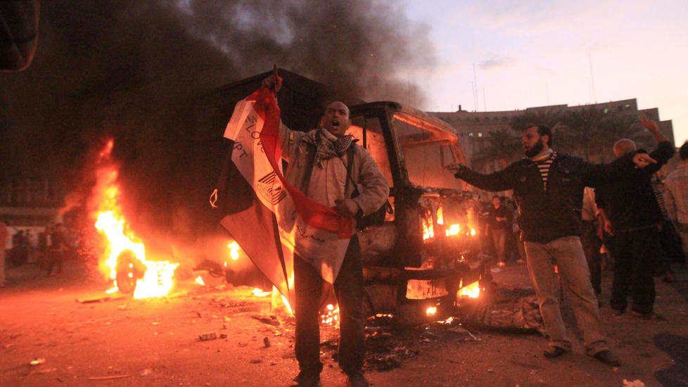 DEMONSTRASJONER: En egyptisk politibil brenner under sammenst�t mellom oppr�rspoliti og demonstranter p� Tahrir-plassen i Kairo.Foto: SCANPIX/AFP PHOTO / KHALED DESOUKI