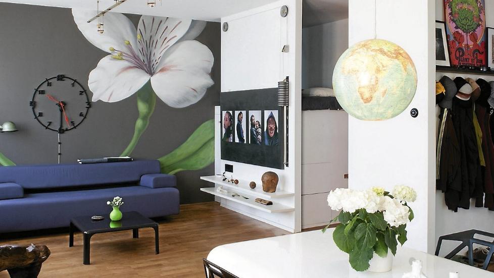 FONDMALERI: Den veggmalte blomsten ved Jonas Wickman/ Arcanum Swedish Design fanger blikket. Hjemmekontoret er ute av syne. Sofaen er fra Cor. Vegglampen er fra Jield�, mens takskinnen er fra Aero Design. Foto: Patrick Miller/House of Pictures