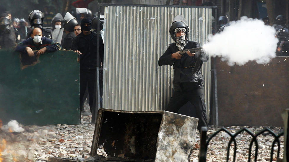 SKYTER: En politimann fra oppr�rspolitiet skyter mot demonstrantene i en sidegate i n�rheten av Tahrir-plassen i Kairo. Foto: SCANPIX/REUTERS/GORAN TOMASEVIC