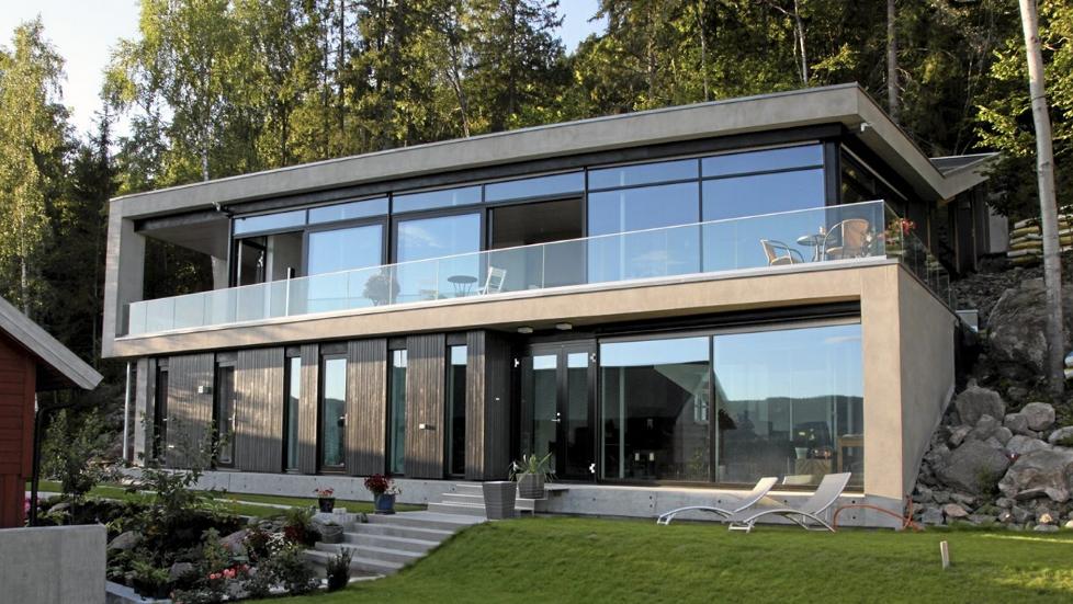 ET BLIKKFANG: Fra utsiden ser vi hvordan de to hovedetstasjene  i mur- og glassvillaen �pner seg raust mot utsikten.  FOTO: Morfeus Arkitekter Peter Przybille
