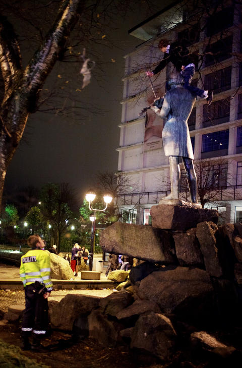 EN GOD IDE... ELLER? En ung mann har satt seg godt til rette på toppen av Ole Bull-statuen. Han kommer ned når politiet viser sin interesse. Mannen forsøker å stige av, men blir raskt innhentet for en alvorsprat i en politibil. Foto: Paul S. Amundsen EN GOD IDE... ELLER? En ung mann har satt seg godt til rette på toppen av Ole Bull-statuen. Han kommer ned når politiet viser sin interesse. Mannen forsøker å stige av, men blir raskt innhentet for en alvorsprat i en politibil. Foto: Paul S. Amundsen