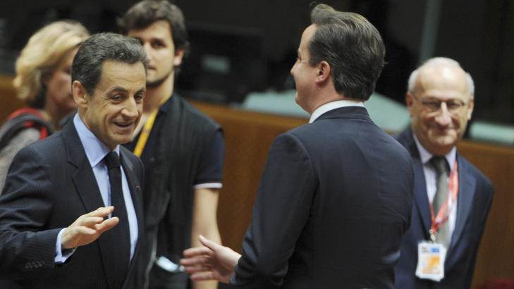 EN L�FTET H�ND: B�de Nicolas Sarkozy og David Cameron l�fter h�yreh�nd, tilsynelatende for � h�ndhilse. Foto: AP Photo/Geert Vanden Wijngaert/Scanpix
