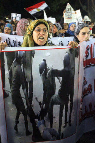 VIL HA EN SLUTT P� VOLDEN: 20. desember str�mmet egyptiske kvinner ut i gatene i Kairo for � vise avsky mot vold mot kvinner. Her holder en kvinne opp bilder hvor en kvinnelig demonstrant bankes opp av soldater. Foto: AFP PHOTO/KHALED DESOUKI