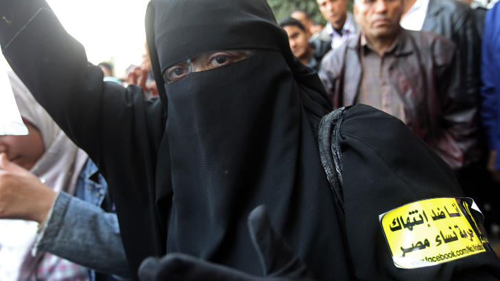 VIL IKKE KRENKES: En egyptisk kvinne i burka demonstrer i Kairo 20. desember. P� armen hennes st�r det Jeg er imot krenkelse av egyptiske kvinners �re. Foto: AFP PHOTO/KHALED DESOUKI