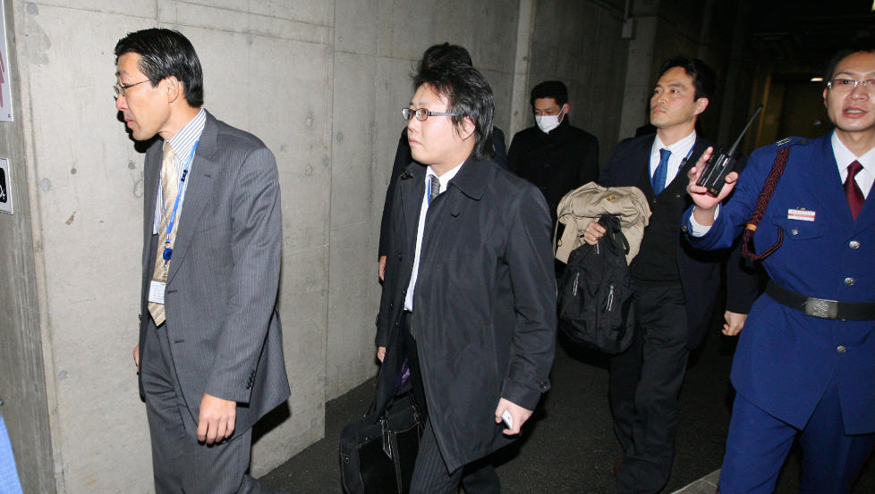 SLO TIL: Her entrer etterforskerne kontoret til Olympus i Tokyo. Foto: AFP/Scanpix