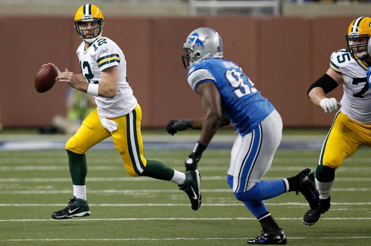 P� SKUDDHOLD: Green Bay Packers' quarterback Aaron Rodgers (t.v.) har en mulighet til � ta Tom Bradys rekord p� 50 touchdown-pasninger, men det er ikke usannsynlig at hovedtrener Mike McCarthy lar sin store stjerne hvile mot Detroit Lions med hjemmebanefordelen i sluttspillet allerede sikret.Foto: SCANPIX/Gregory Shamus/Getty Images/AFP