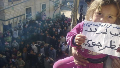 En liten jente holder frem en plakat hvor det st�r �folk vil ha en flyforbudssone�  under en demonstrasjon i Homs 27. desember. Foto: REUTERS/Handout