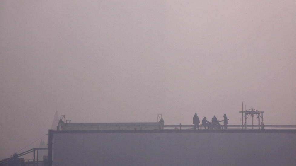  SOLENS RIKE I MORGES:  Kinesiske bygningarbeidere i gang p� jobb i Beijing i morges - etter at sola har st�tt opp i ly for rekordtett smog over den kinsesiske hovedstaden. FOTO: DAVIDGRAY, REUTERS/SCANPIX.