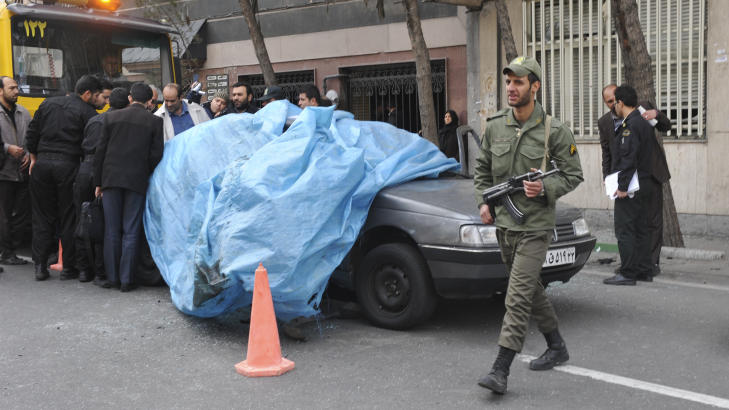 SKYLDER P� ISRAEL: En politimann passerer bilen til Mostafa Ahmadi-Roshan. Iranske myndigheter har gitt Israel skylden for atentatet. Foto: REUTERS/IIPA/Sajad Safari