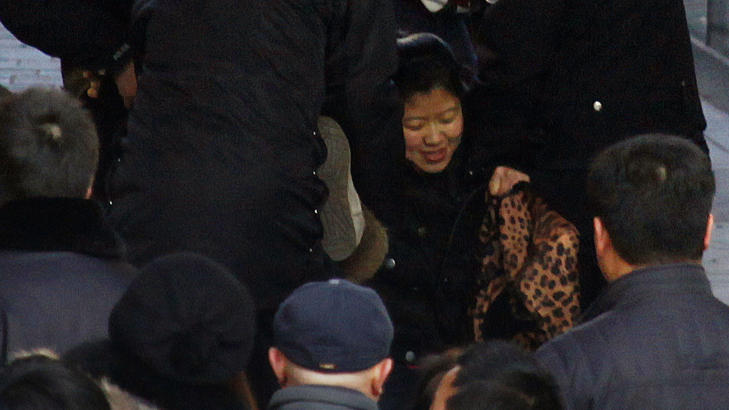 DRATT BORT: En kvinne blir dratt bort av sikkerhetsvakter. Foto: David Gray/Reuters/Scanpix