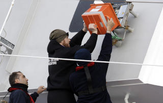 Tre ansatte i den italienske kystvakten sikrer seg b�tens ferdsskriver , som registrerer hva som har skjedd p� broen forut for hendelsen. Foto: REUTERS/ Remo Casilli