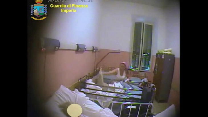 LUGGER PASIENTEN:  Her drar pleieren pasienten i h�ret for � f� vedkommende i seng. Foto: Guardia di Finanza Imperia/San Remo News