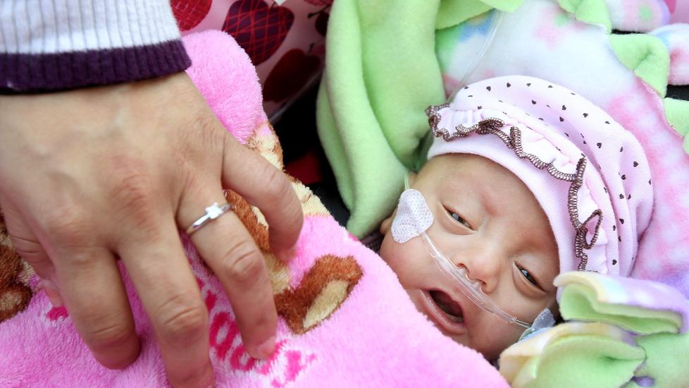  P� vei hjem:  Bitte-lille Melinda Star Guido ble dekket inn i et rosa teppe da hun endelig kunne forlate sykehuset, fem m�neder etter at hun br�tt kom til verden som en av de minste overlevende babyene vi har sett. Foto: AFP / Scanpix.