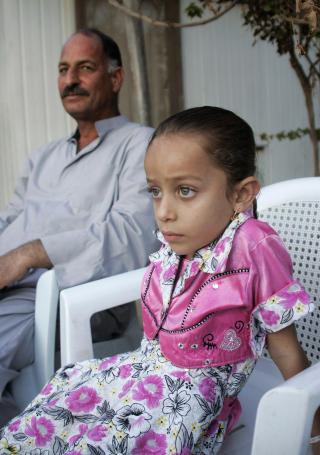 OVERLEVDE: B�de kvinner og barn ble drept i angrepet. Lille Hind overlevde, her sitter hun med onkelen sin. Foto: Reuters/Ali al-Mashhadani/Scanpix