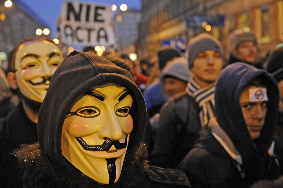 PROTESTERER: Demonstranter i Polen protesterer mot at regjeringen vil signere ACTA. Det gjorde den,sammen med en lang rekke andre EU-land,  i dag. Foto: SCANPIX