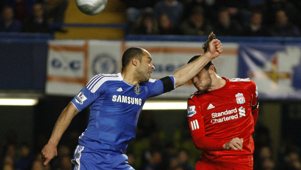 Chelsea's Alex, left, jumps for the ball with Liverpool's Andy Carroll, Alex was given a yellow card for hand ball during the English League Cup quarter final soccer match between Chelsea and Liverpool, in London, Tuesday, Nov. 29, 2011. (AP Photo/Kirsty Wigglesworth)