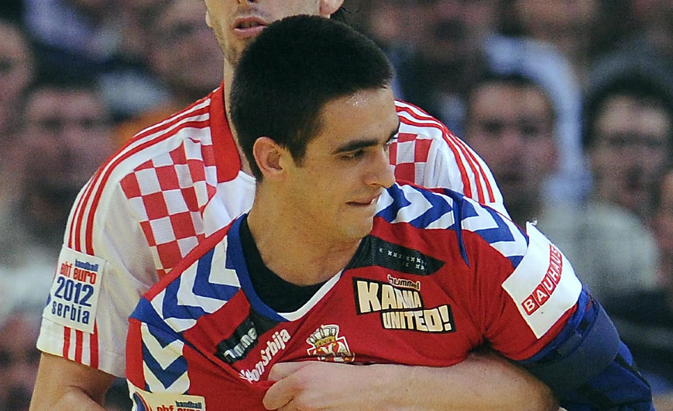 KAN BLI BLIND: Serbias Zarko Sesum ble truffet av en dartpil i kamp mot Kroatia i h�ndball-EM: Foto: AFP PHOTO / FRANCK FIFE
