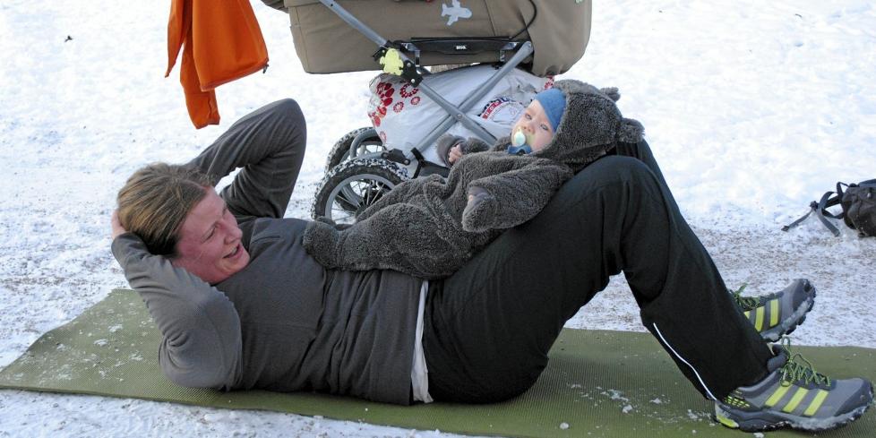 P� TRENING MED MAMMA: Trenings�kten n�rmer seg slutten og tre m�neder gamle Theodor er lei av � ligge i vogna. Mamma Hanna Torgersen underholder en ut�lmodig gutt samtidig som hun tar sit ups. Foto: Marthe Kaasa F�r�