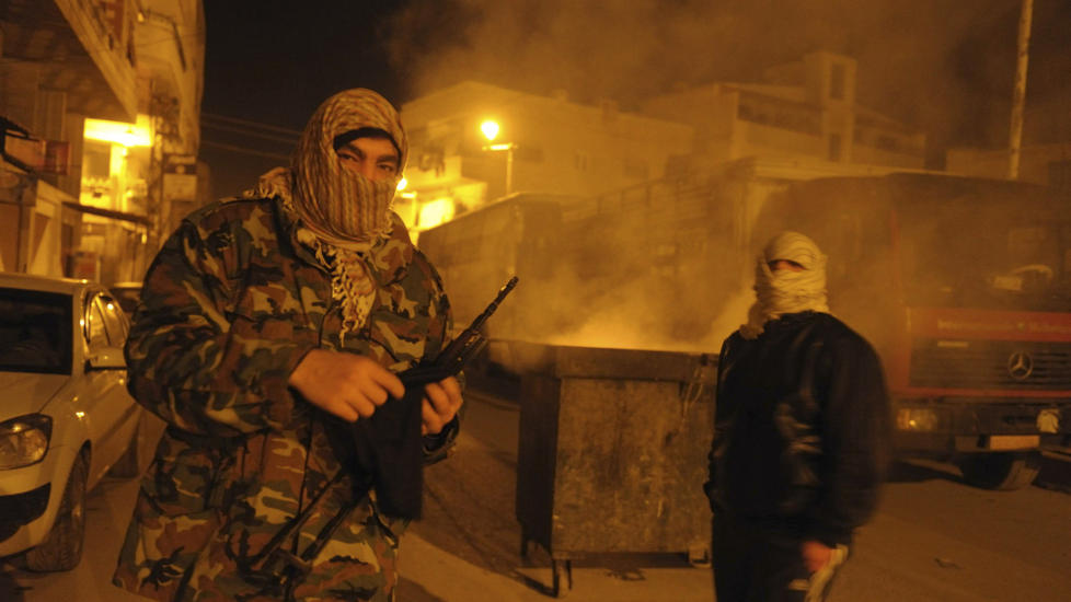 BLOKKERER: Supportere av Free Syrian Army (FSA) blokkerer en gate i Damaskus, som protest mot angrepene i Homs. Foto: REUTERS/Scanpix