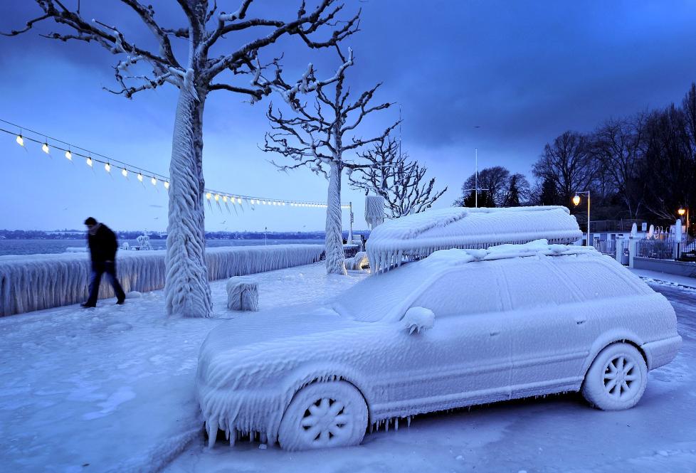 NEDFROSSET: En mann passerer en nedfrosset bil i Versoix n�r Geneve. D�dstallene for kuldeb�lgen i Europa stiger og s� langt har mer enn 420 mennesker mistet livet. Meteorologene sp�r mer kulde i dagene som kommer. Foto: Fabrice Coffrini / AFP / Scanpix