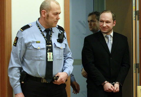 SMILTE: Anders Behring Breivik smilte til framm�tt press og tilh�rere da han ankom rettsal 828 i Oslo Tinghus i dag. 
Foto: Heiko Junge / Scanpix