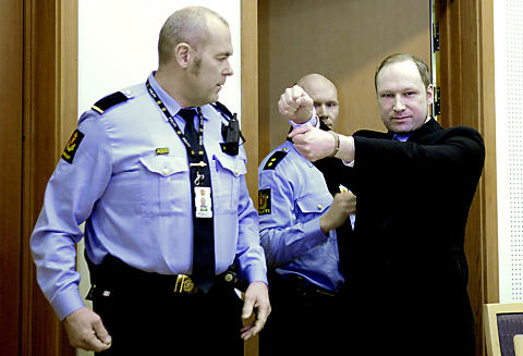 I RETTEN: Anders Behring Breivik ankommer rettssal 828 i Oslo Tinghus. Da han ankom rettslokalet smilte han og viste fram h�ndjernene han var p�satt. Foto: Nina Hansen / Dagbladet